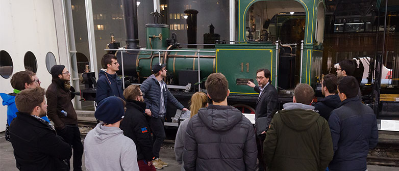 Studierende bestaunen die Dampflokomotive E2/2, Nr. 11 der Gotthardbahn – Führung im Verkehrshaus der Schweiz mit This Oberhänsli